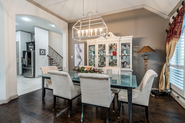 dining area with dark hardwood / wood-style floors, ornamental molding, and a notable chandelier