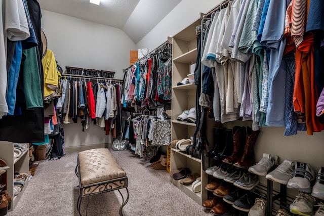 walk in closet with lofted ceiling and carpet flooring