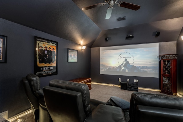 cinema room with lofted ceiling, ceiling fan, carpet, and a textured ceiling