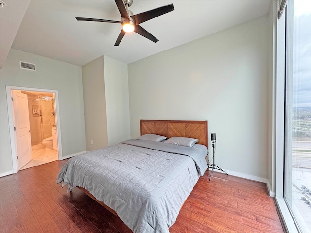 bedroom with hardwood / wood-style floors, ensuite bathroom, and ceiling fan