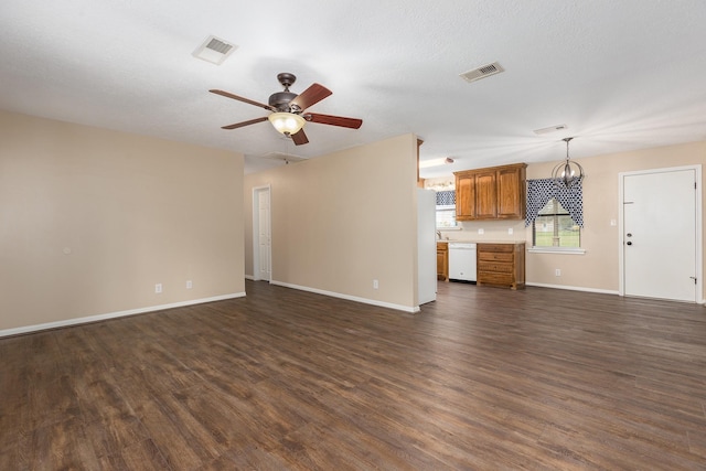 unfurnished living room with dark wood-style floors, baseboards, visible vents, and a ceiling fan