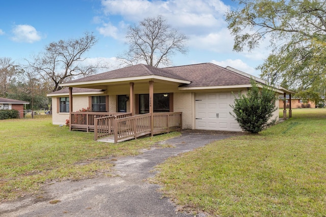 ranch-style home featuring driveway, roof with shingles, an attached garage, a front lawn, and brick siding