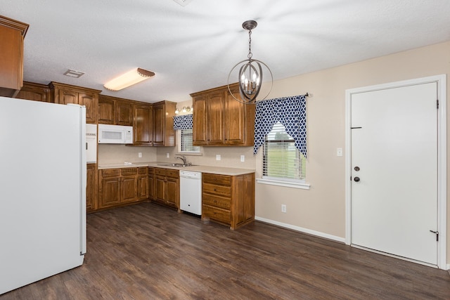 kitchen featuring light countertops, white appliances, brown cabinets, and pendant lighting