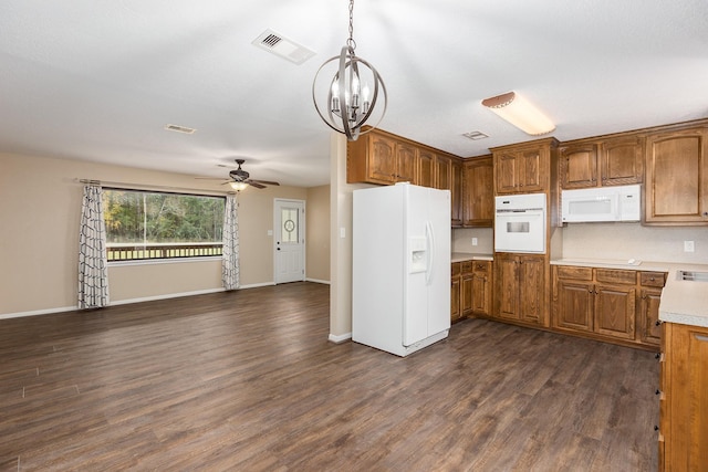 kitchen with brown cabinets, white appliances, light countertops, and decorative light fixtures