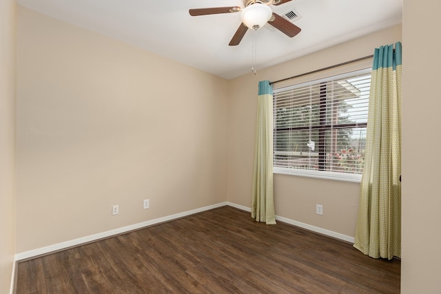 empty room featuring dark wood-style floors, ceiling fan, and baseboards