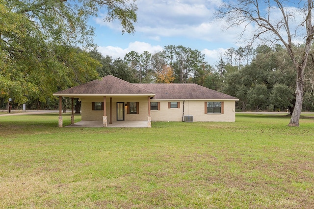 rear view of house with a shingled roof, central AC, a lawn, and a patio