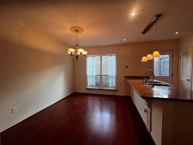 kitchen featuring kitchen peninsula, decorative light fixtures, plenty of natural light, and sink