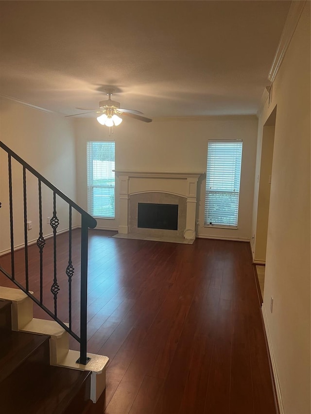 unfurnished living room featuring ceiling fan, crown molding, and dark wood-type flooring