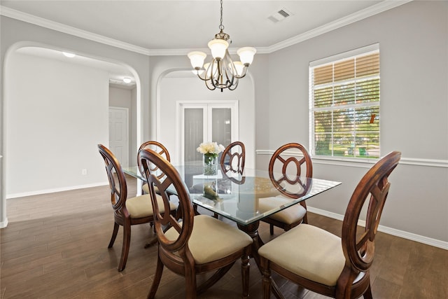 dining room featuring crown molding, dark hardwood / wood-style floors, and an inviting chandelier