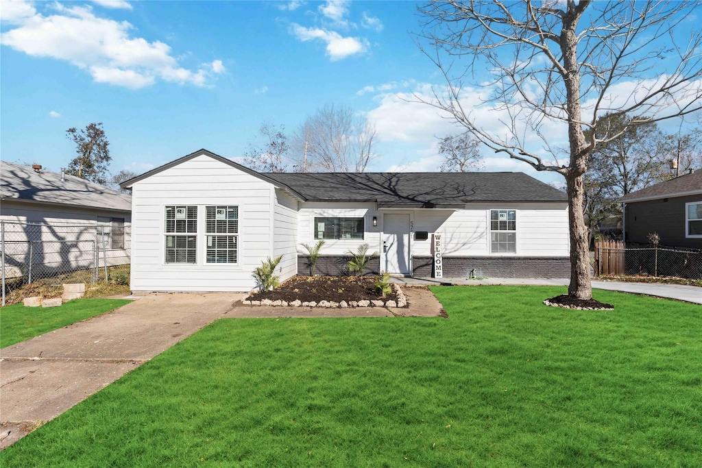 rear view of property featuring a lawn