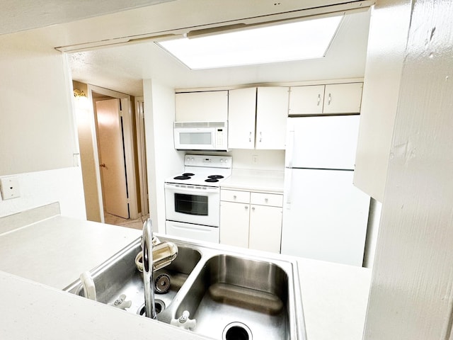 kitchen featuring white cabinetry, white appliances, and sink