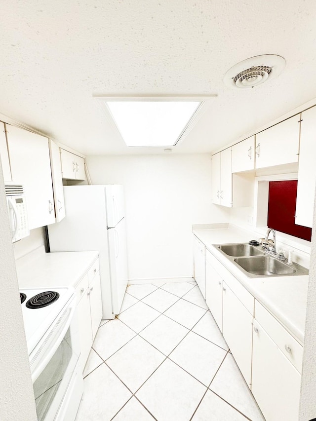 kitchen with white cabinets, white appliances, sink, and light tile patterned floors