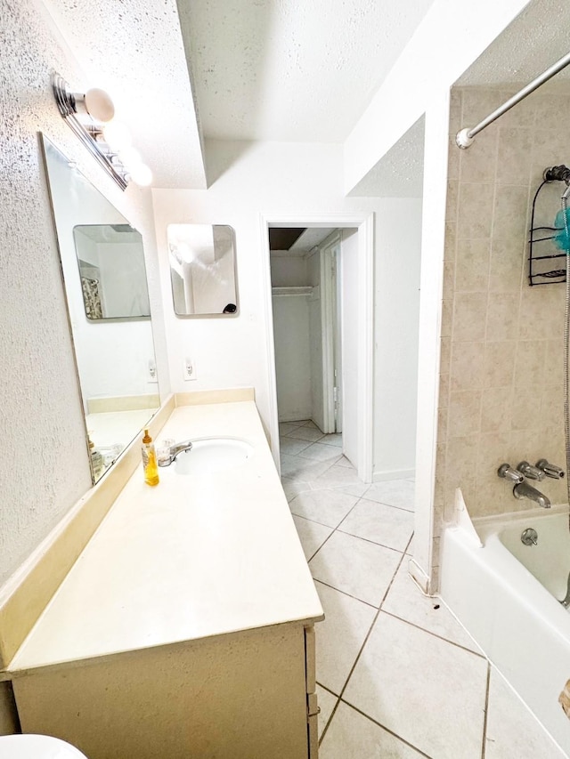 full bathroom with tile patterned floors, a textured ceiling, vanity, and tiled shower / bath combo