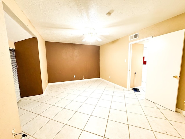 tiled empty room with a textured ceiling and ceiling fan