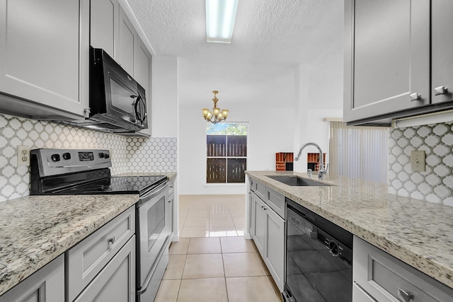 kitchen featuring light stone counters, sink, light tile patterned flooring, and black appliances