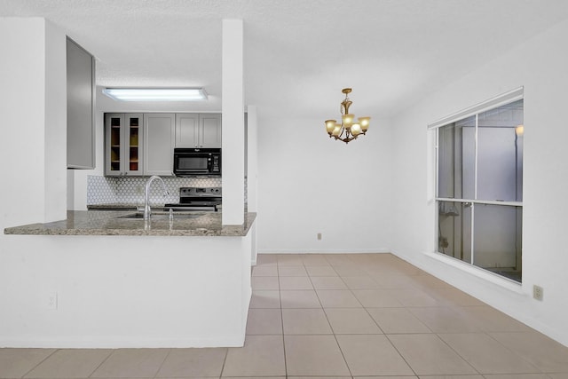 kitchen featuring stone counters, a notable chandelier, stainless steel electric range, gray cabinets, and decorative backsplash