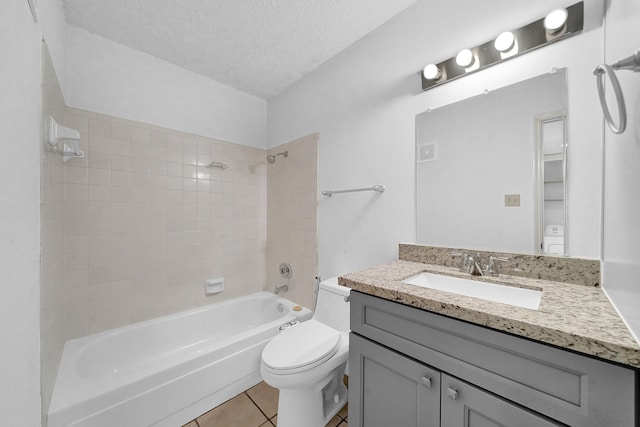 full bathroom featuring vanity, tile patterned flooring, tiled shower / bath combo, toilet, and a textured ceiling