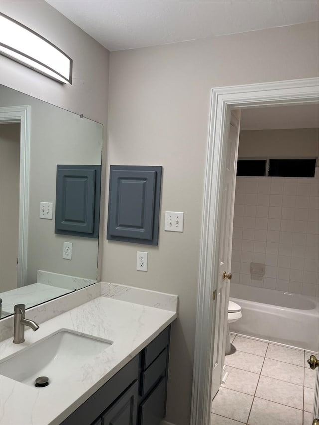 full bathroom featuring tile patterned flooring, vanity, toilet, and tiled shower / bath combo