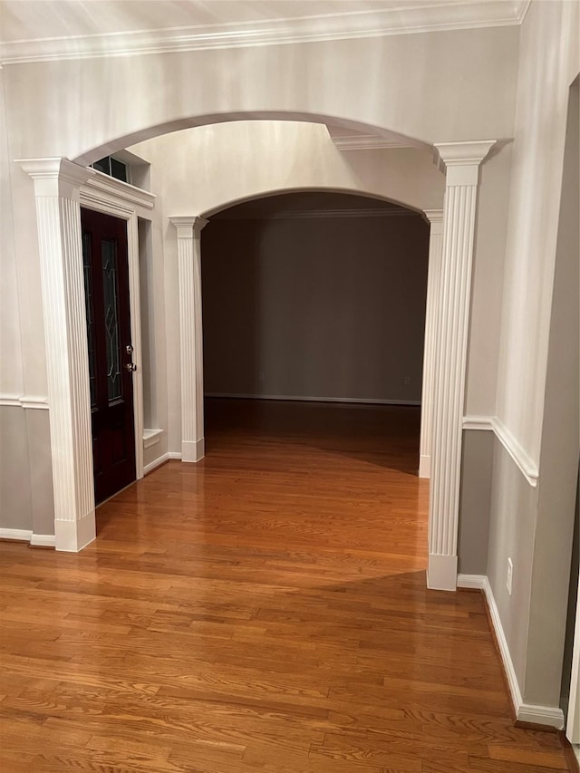 hallway with hardwood / wood-style floors and ornamental molding