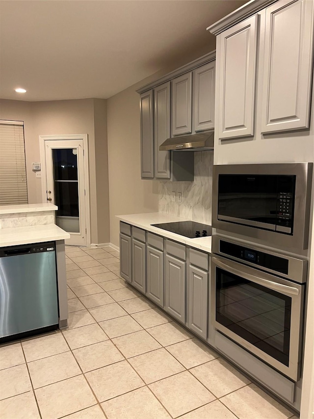 kitchen with gray cabinetry, light tile patterned flooring, and stainless steel appliances