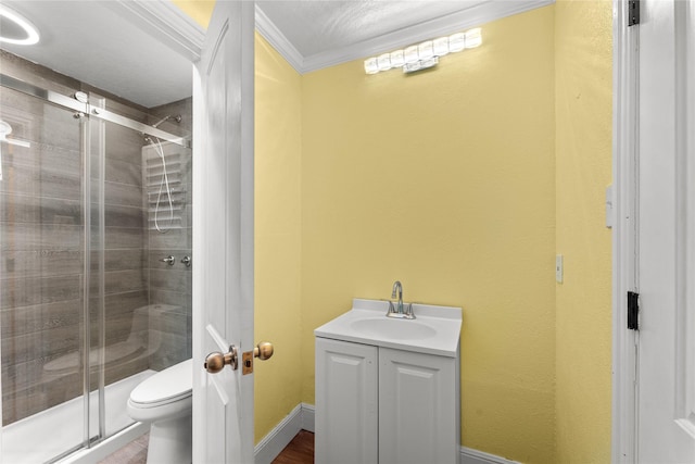 bathroom featuring vanity, toilet, crown molding, and walk in shower