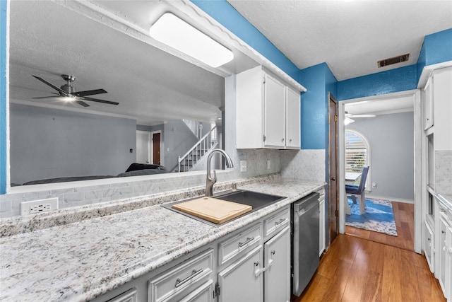 kitchen with a textured ceiling, dark wood-type flooring, sink, dishwasher, and white cabinetry