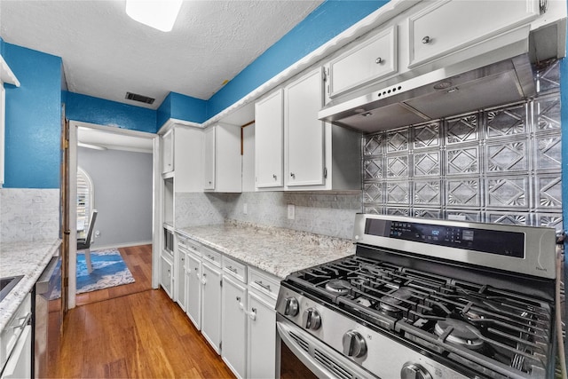 kitchen with wood-type flooring, tasteful backsplash, white cabinetry, and stainless steel gas range oven