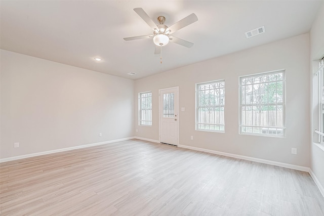 empty room with ceiling fan and light hardwood / wood-style flooring