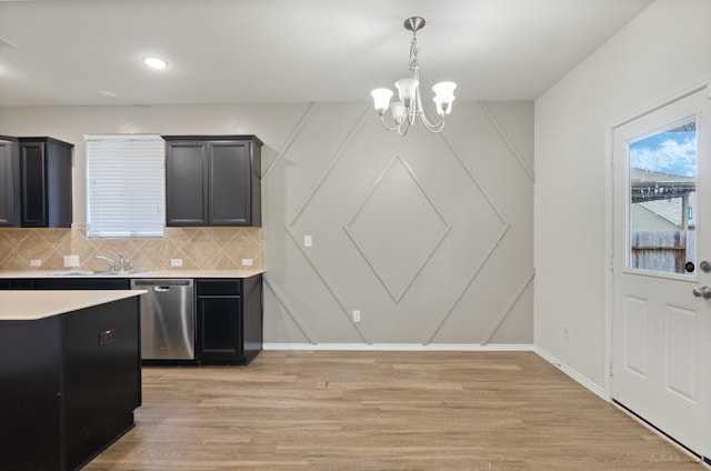 kitchen with tasteful backsplash, light hardwood / wood-style floors, sink, a notable chandelier, and stainless steel dishwasher