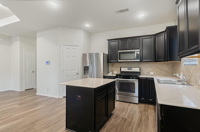 kitchen featuring light hardwood / wood-style floors, sink, stainless steel appliances, and a kitchen island