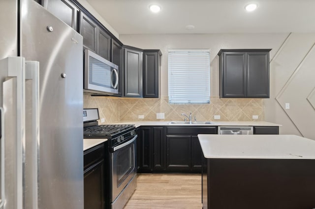 kitchen featuring a kitchen island, light hardwood / wood-style floors, decorative backsplash, sink, and appliances with stainless steel finishes