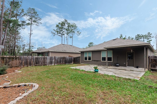 back of house featuring a lawn and a patio area