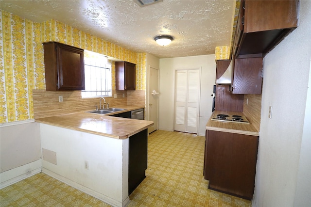 kitchen featuring white gas stovetop, backsplash, sink, a textured ceiling, and kitchen peninsula