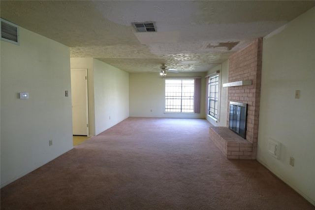 unfurnished living room with ceiling fan, a textured ceiling, light carpet, and a brick fireplace