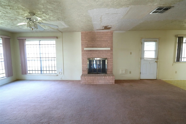 unfurnished living room featuring a fireplace, carpet floors, a wealth of natural light, and ceiling fan