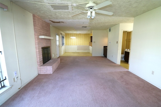 unfurnished living room featuring light carpet, a textured ceiling, a brick fireplace, and ceiling fan