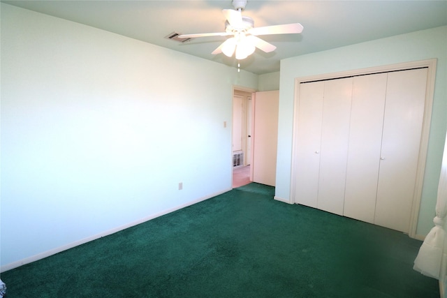 unfurnished bedroom featuring dark colored carpet, a closet, and ceiling fan