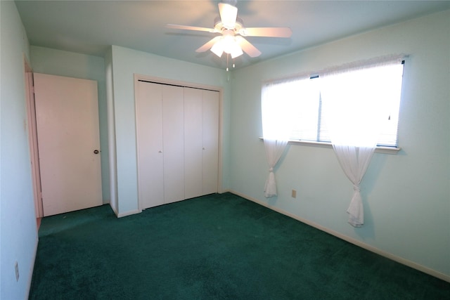 unfurnished bedroom featuring ceiling fan, dark carpet, and a closet