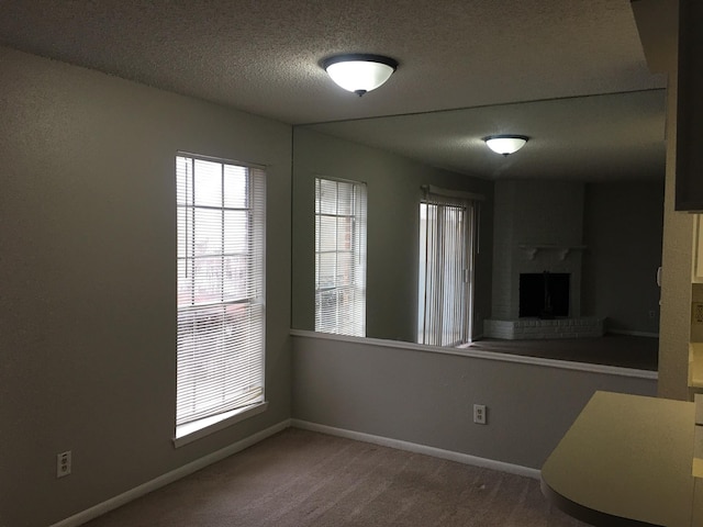 interior space featuring a textured ceiling and a brick fireplace