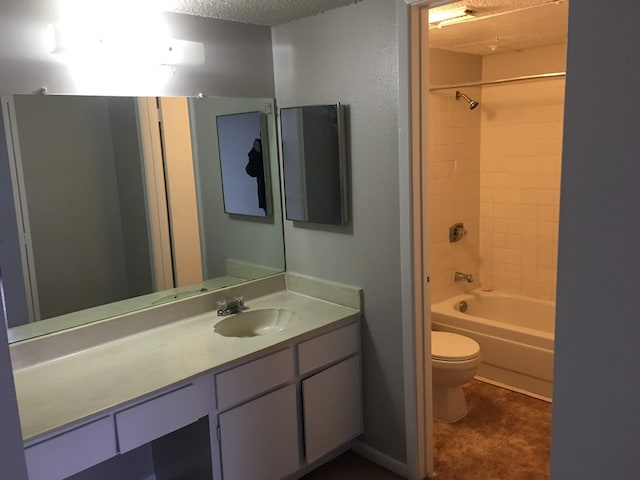 full bathroom with washtub / shower combination, a textured ceiling, vanity, and toilet