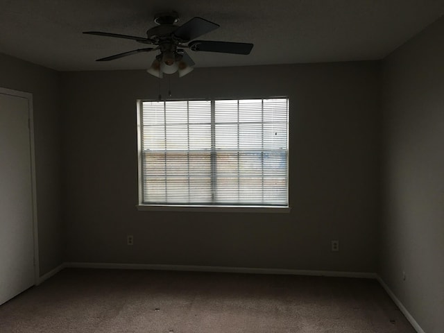 empty room with carpet, plenty of natural light, and ceiling fan