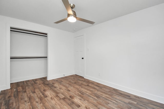 unfurnished bedroom with ceiling fan, a closet, and dark wood-type flooring