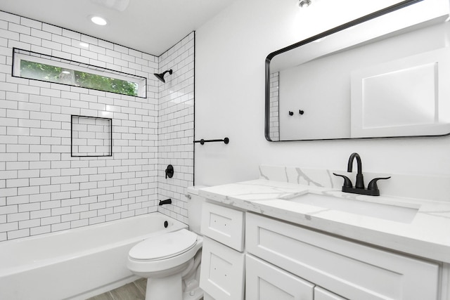 full bathroom with vanity, hardwood / wood-style flooring, toilet, and tiled shower / bath