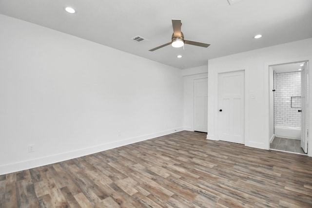 unfurnished bedroom featuring ceiling fan, a closet, wood-type flooring, and ensuite bath