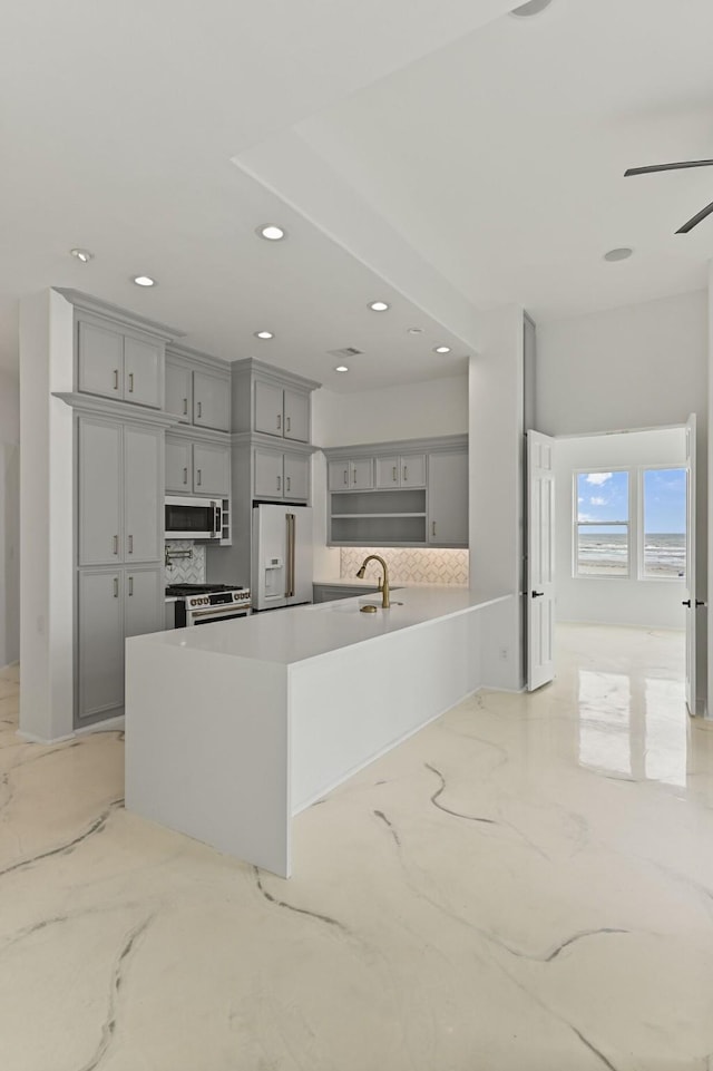 kitchen featuring appliances with stainless steel finishes, gray cabinets, light countertops, and recessed lighting