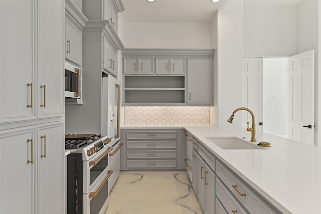 kitchen with stainless steel microwave, light countertops, double oven range, open shelves, and a sink