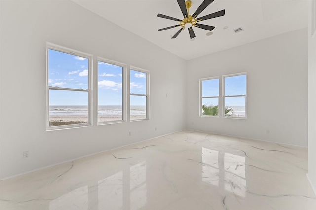 spare room featuring a water view, visible vents, and a ceiling fan