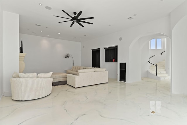 living room with arched walkways, marble finish floor, visible vents, and recessed lighting