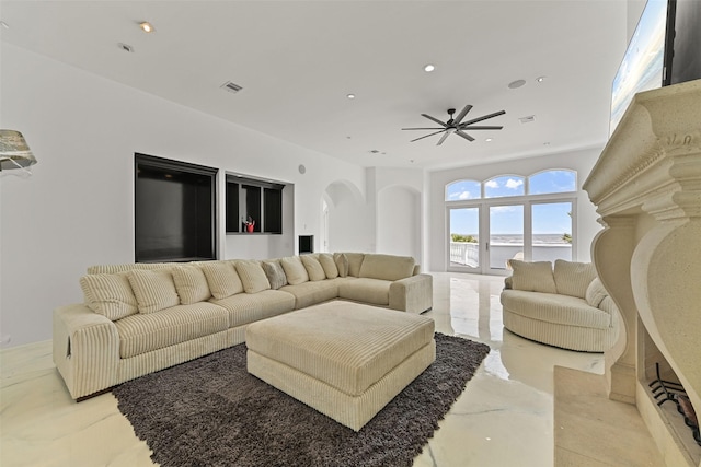 living area featuring ceiling fan, arched walkways, visible vents, and recessed lighting