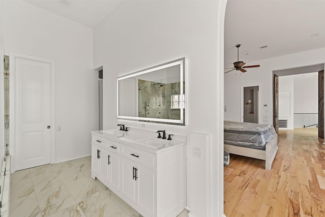 bathroom featuring marble finish floor, ensuite bath, a sink, and a stall shower